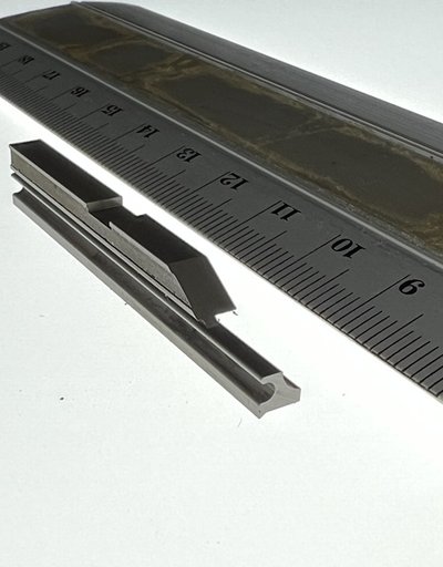 定規の横に置いた細いパンチ部品